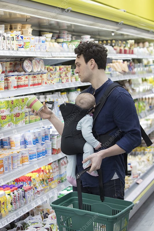 Father with baby daughter grocery shopping in supermarket ...