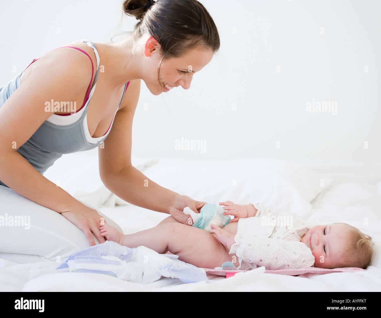 Mother changing babyâs diaper Stock Photo